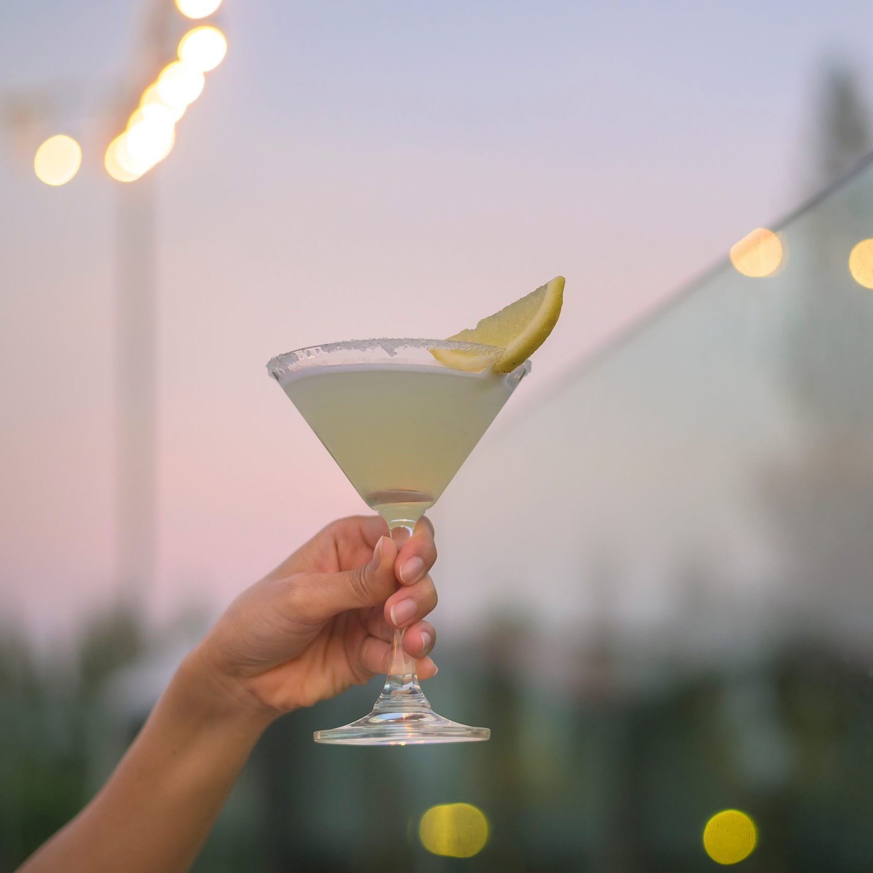 Close Up Human Hand Holding A Glass Of Alcohol Beverage In Restaurant